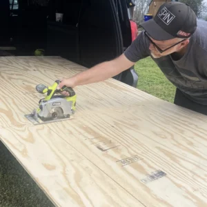 Marshall Shartzer III cutting plywood for the Roaming Home minivan camper conversion build